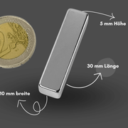 Rechteckiger Neodym-Quadermagnet im Größenvergleich mit einer 1-Euro-Münze, Maße 30 mm Länge x 10 mm Breite x 5 mm Höhe